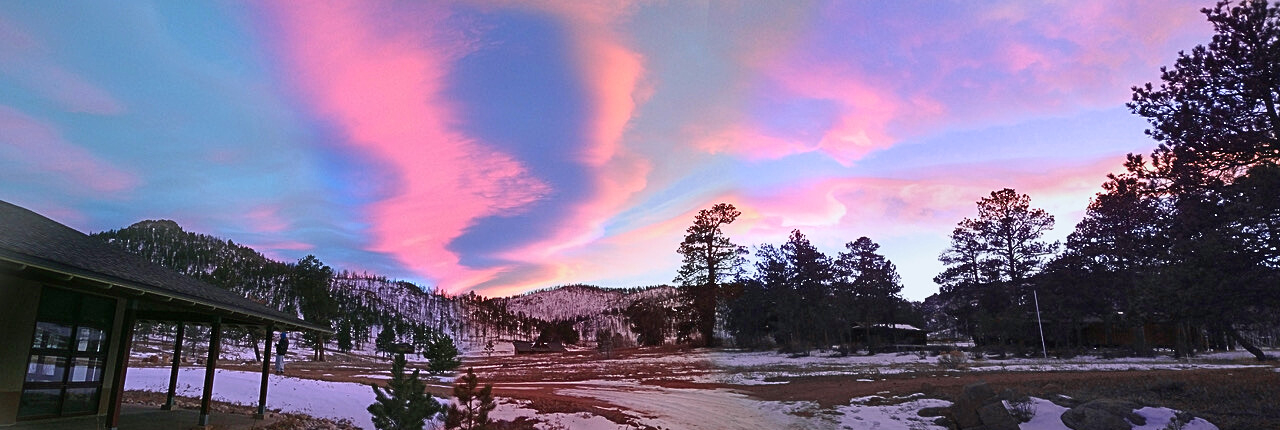 Edited - Sunset Over Drala Mountain Center by Greg Smith A beautiful vibrant pink and blue sunset showing clouds wavering over the ponderosa pine-filled valley of Drala Mountain Center